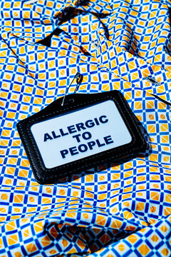 Name tag with text 'Allergic to People' on a colorful geometric shirt