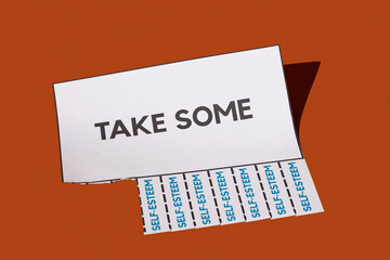 Tear-off advert with text 'Take Some' and 'Self-Esteem' on paper strips in a studio setting