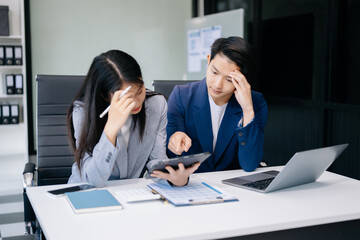 Furious two Asian businesspeople arguing strongly after making a mistake at work in office.