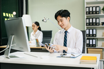 Young businessman working at office with laptop, tablet and taking notes on the paper..