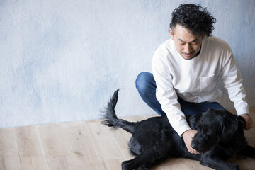 大型犬と遊ぶ男性　人間が触って嫌にならないように躾をする