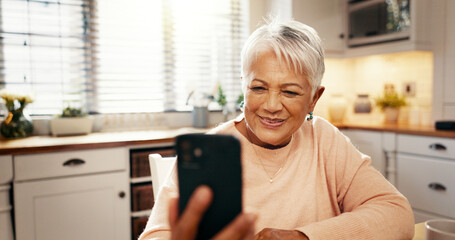 Phone, video call and senior woman in kitchen with communication, networking or contact. Happy, technology and elderly female person with cellphone for virtual conversation on mobile app in home.