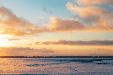 Beautiful bright sunset over a snow-covered field.
