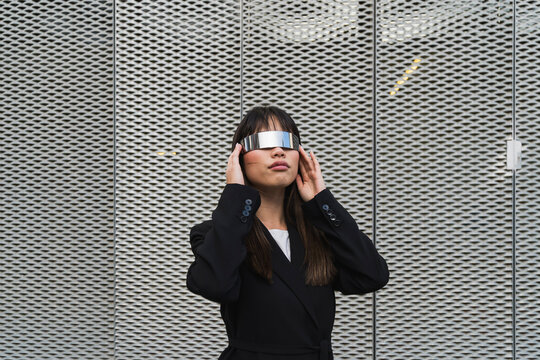 Asian businessoman wearing cyberglasses in a futuristic suit