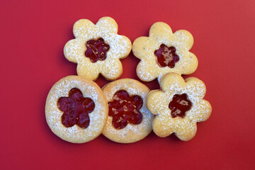 Linzer cookies on a red background, flowers and round shape. Homemade baking