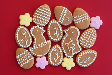 Easter gingerbread cookies in a shape of egg, chicken and flowers, red background