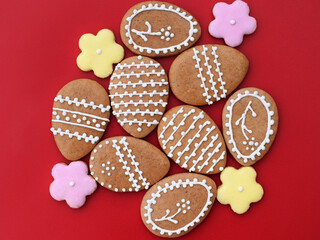 Easter gingerbread cookies in a shape of egg and flowers, red background