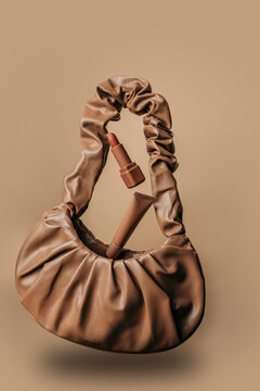 Brown bag with cosmetics levitating in air showcasing Mocha Mousse concept