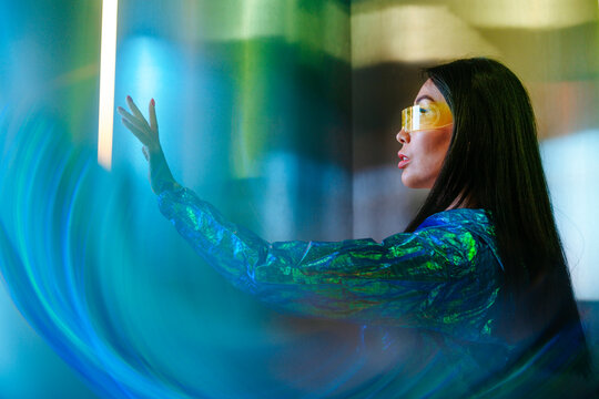 Futuristic woman wearing glasses in a neon-lit environment