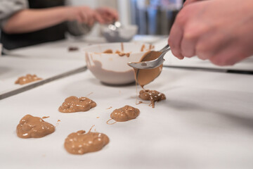 A child using a spoon to create a sweet dessert with milk chocolate and nuts. Ideal for family cooking, homemade treats, or kids' activities, food, dessert, and playful moments.