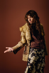 Stylish young man poses confidently with unique fashion choice in warm toned studio