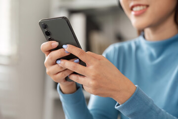 Technology and Daily Communication. A woman using her smartphone to connect with friends and family.