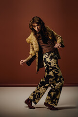 Stylish young man showcasing unique fashion in an artistic studio setting during modern photoshoot