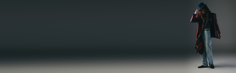 Stylish young man poses confidently in a minimalist studio setting during a fashion showcase