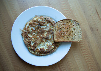 Fried Omelet with Toast on White Plate Top View