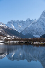 Dombay, Karachay-Cherkessia. Teberda National Park. Lake Tumanly-Gel or Tumanly-Kol (Misty Lake) is in valley of Gonachkhir River. Snowy peaks of Mount Chotcha are reflected in lake as in mirror.