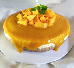 Delicious Mango Cheesecake with Fresh Mango Toppings and Mint Garnish