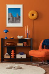 Close-up of modern orange lounge chair and bookshelf against a bold terracotta wall in a cozy home...