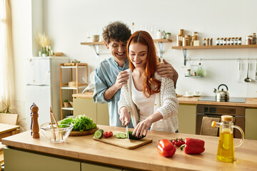 Young couple sharing joy while cooking together in a cozy home kitchen setting