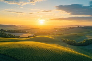 Fototapeta premium The golden sunset illuminates rolling hills and distant rural landscape