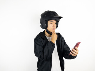 Asian man wearing helmet holding mobile phone showing thinking about something gesture isolated on white background