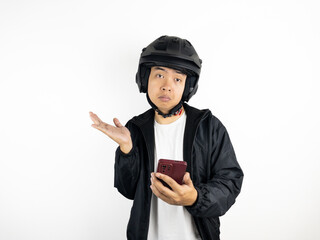 Asian man wearing helmet holding mobile phone showing thinking about something gesture isolated on white background