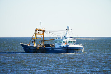 Landscape on the North Sea with a fishing boat near Sylt.
