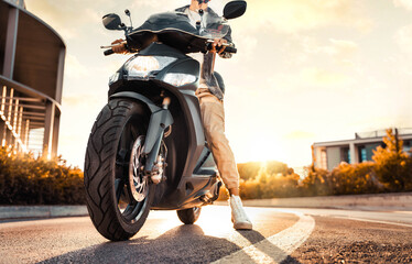 Male driver driving moto scooter in city street - Transportation life style concept