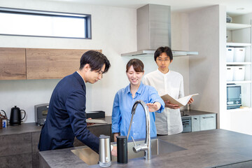 Obraz premium Housing sales: Japanese person explaining kitchen in model house