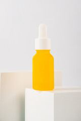 Plastic yellow tube for cream or lotion. Skin care or sunscreen cosmetic with stylish props on white background.