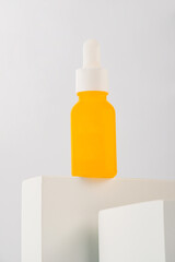 Plastic yellow tube for cream or lotion. Skin care or sunscreen cosmetic with stylish props on white background.