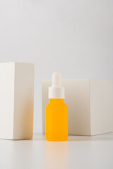 Plastic yellow tube for cream or lotion. Skin care or sunscreen cosmetic with stylish props on white background.