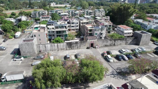 Aerial view of Kun Lung Wai Walled Village, showcasing the houses, parked cars and green trees