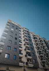 Residential high-rise architecture with modern design and urban surroundings under a bright sunny day.