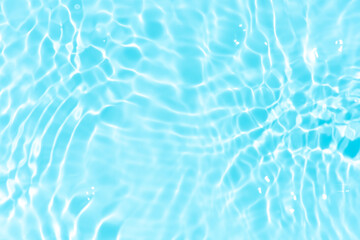 Blue water with ripples on the surface. Defocus blurred transparent blue colored clear calm water surface texture with splashes and bubbles. Water waves with shining pattern texture background.