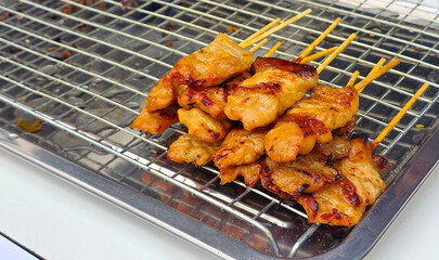 Stack of delicious grilled prok skewers resting on a stainless steel tray after cooking, ready for serving or packaging