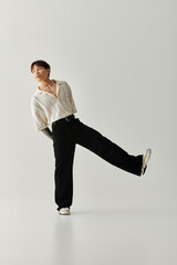 Stylish young Asian man striking a confident pose in modern minimalist studio setting