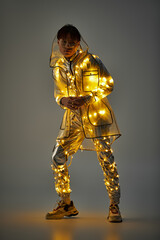 Fototapeta premium Stylish young man adorned with glowing lights in a modern urban environment during the evening