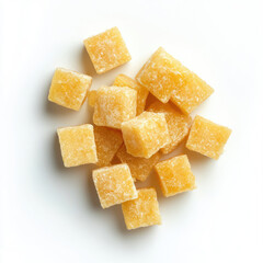 A top down view of a pile of yellow cubed candies on a white background