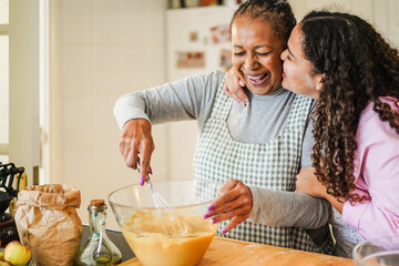 African american mother and daughter having fun preparing sugar free cake at home - Family lifestyle, mom day and cooking healthy food concept - Focus on mum face
