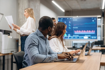 Obraz premium Laptops on the table. Group of office workers are indoors together