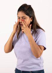 Indian young woman suffering from nose pain running and feeling cold on white