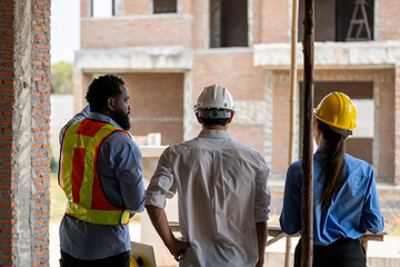 Construction engineers supervising progress of construction project. engineering or worker in safety vest observing a building A team of construction engineers. workers at the construction site. 