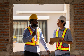 Construction engineers supervising progress of construction project. engineering or worker in safety vest observing a building. worker, Architecture, engineer, architect wearing safety helmet meeting.