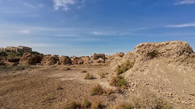 Ancient ruins in a desert landscape under a clear blue sky in ancient city of Babylon, Iraq