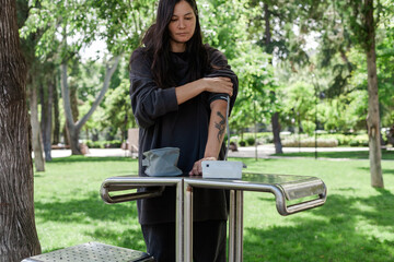 Woman checking blood pressure with a digital monitor. Concept of heart health, hypertension...
