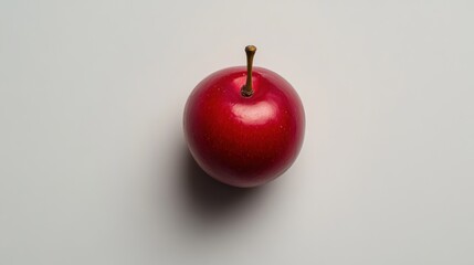 Single red plum on plain white background