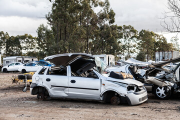 Wrecked and smashed cars parked in car wreckers junkyard