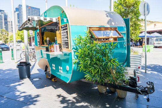 A brightly painted vintage caravan set up as a coffee van