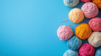 Colorful yarn balls are on a light blue background with copy space. It can be used for hobbies, crafting, or creative projects.